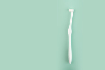 special toothbrush for cats and small dogs on a green background, copy space