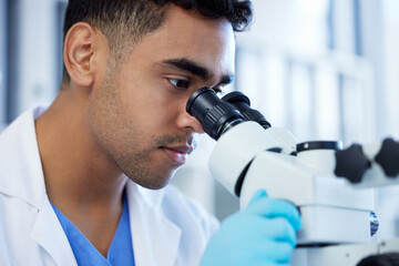 Science, innovation and a man with microscope in a lab for medical research and analysis. Serious,...