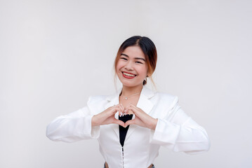An upbeat and young asian woman posing with a head heart on her chest. Isolated on a white...