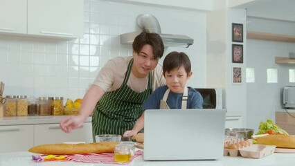 Happy smiling Young Asian father and son making video call to mother. enjoy cooking in kitchen at home