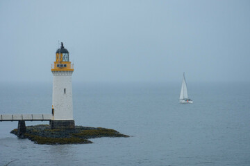 A lighthouse overlooking the sea by a scottish island
