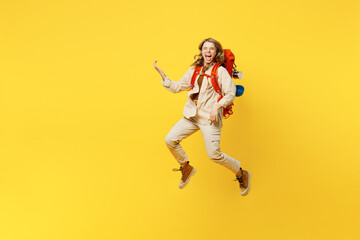 Fototapeta na wymiar Full body young woman carry bag with stuff mat jump high pov play guitar isolated on plain yellow background. Tourist leads active lifestyle walk on spare time. Hiking trek rest travel trip concept.