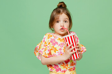 Little child kid girl 6-7 years old wear casual clothes have fun hold in hand cup of soda pop fizzy...