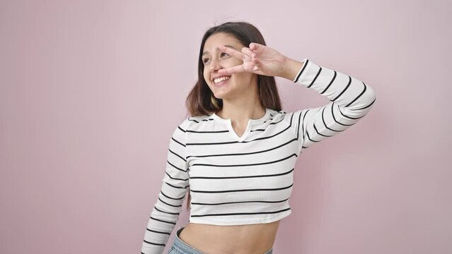 Young beautiful hispanic woman smiling confident dancing over isolated pink background