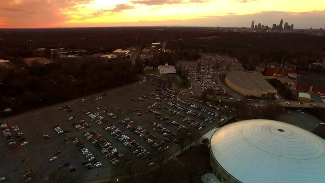 Aerial Tilt Down Shot Of Ovens Auditorium And Bojangles Coliseum In City, Drone Flying Over People Standing In Queue At Sunset - Charlotte, North Carolina