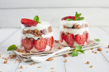 Traditional strawberry trifle desserts in glasses on wooden table