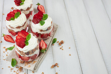 Traditional strawberry trifle desserts in glasses on wooden table - obrazy, fototapety, plakaty
