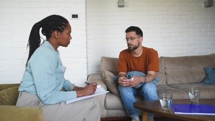 Stressed worried man suffering from depression and anxiety counselor providing professional assistance psychotherapy. Unhappy male patient consultation with psychologist, receiving therapy help