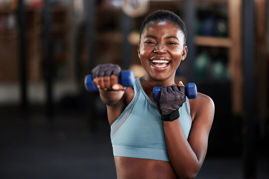 Portrait of boxer, dumbbell or happy black woman training, exercise or workout for a strong punch or power. Smile, face or African girl boxing with dumbbells, weights or exercising in fitness gym