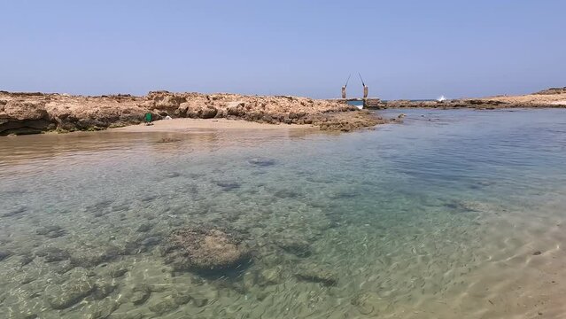 Experience the breathtaking beauty of a wild beach near Atlit, north of Israel. This stock video showcases the clear turquoise waters and tranquil atmosphere of the Mediterranean bay.