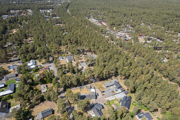 Fototapeta na wymiar Aerial view of big forest with camping. Beautiful landscape of nature, many trees. Resort and recreational area, private houses, luxury real estate. 