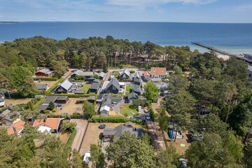 Fototapeta premium Aerial view private houses close to the beach and sea. Beautiful sea, maritime landscape, seascape. Forest near the beach. Resort and recreational area, luxury real estate. 