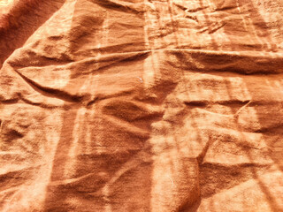 Abstract background and texture of crumpled brown satin fabric. Texture, pattern, frame, copy space