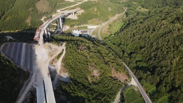 Highway bridge under construction. Aerial view of nes road. Freeway being built on a mountain terrain..