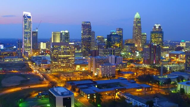 Aerial Shot Of Illuminated Buildings In Modern City Against Sky, Drone Flying Backward Over Cityscape At Dusk - Charlotte, North Carolina