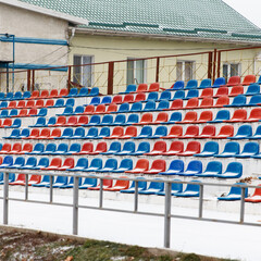 Places where fans sit, plastic chairs in a football stadium, in winter