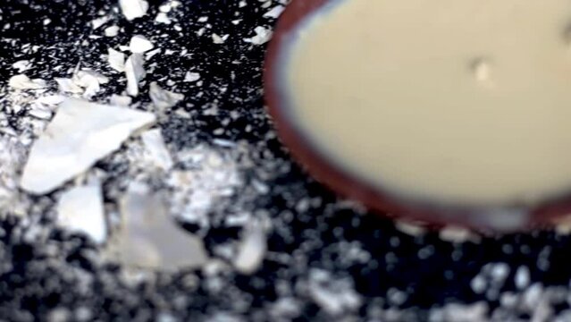 Multani mitti or Fuller's earth on a black surface and its paste in a clay bowl used for face masks and face packs for naturally glowing skin. HD footage in 24FPS.