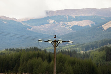 A telegraph pole with mountains in the background
