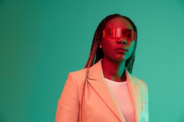 African american woman smile and fashion wearing glasses green background in neon light color mixed light, bright color dancing, futuristic party. Beauty African American woman with pigtails emotions.
