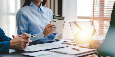 Young colleagues discussing business and charts in office room. Analyze, finance, accounting, tax, marketing, teamwork concept.