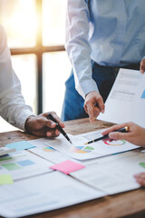 Young colleagues discussing business and charts in office room. Analyze, finance, accounting, tax, marketing, teamwork concept.