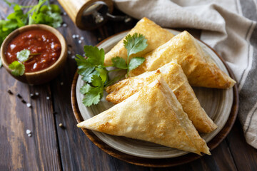 Asian food. Vegetarian samsa (samosas) with tomato sauce on a wooden table. Popular in Indonesia as Risoles Sayur.