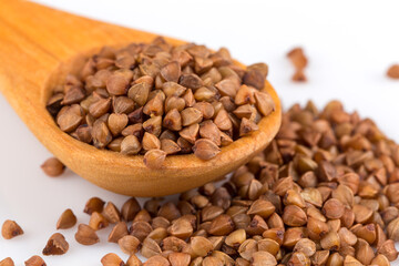 Uncooked buckwheat on wooden spoon