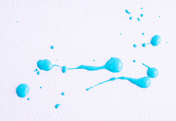 Watercolor light blue drop splash. Splattered of bright blue ink drops on white paper background. Sample of cosmetics. The puddle of an oil paint spill