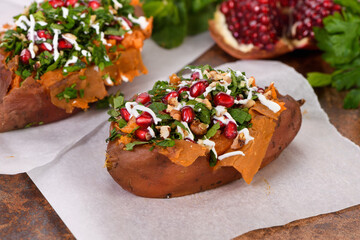 Baked stuffed sweet potatoes filled with walnuts, fresh herbs, mint and pomegranate seeds. The tahini sauce makes them excellent. It is a healthy side dish or main dish for vegans and paleo.