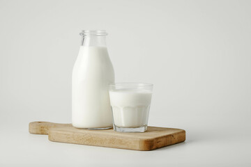 A glass and bottle of milk of milk on a white background