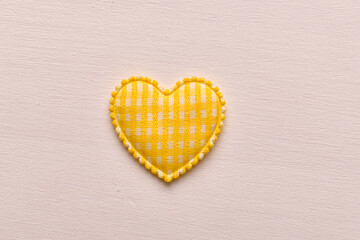 Cloth heart close-up on a wooden light surface. Close-up. Background. Texture.