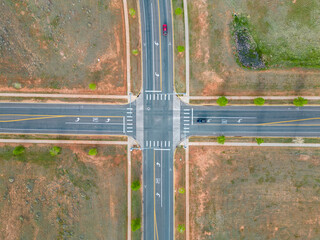 Top down view of intersection of road with cars at stoplights from aerial drone