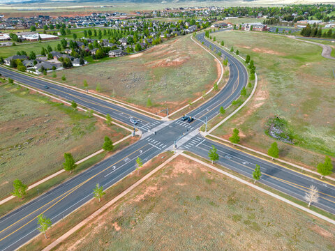 Road intersection with stoplights and cars from aerial drone