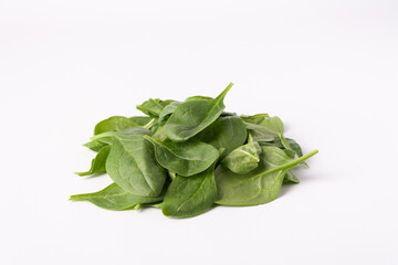 a pile of spinach leaves on white, copy the space