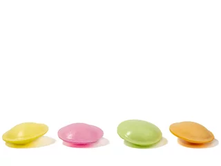 Zelfklevend Fotobehang Sweet candies in the shape of a UFO in different colors on a white background. Flying saucers sugar paper in the shape of a spaceship with sherbet. © Jakob