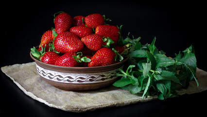 Strawberries in a ceramic bowl on a black background