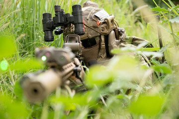 Special forces soldier in camouflage with a pair of weapons that are full of modern technology and...