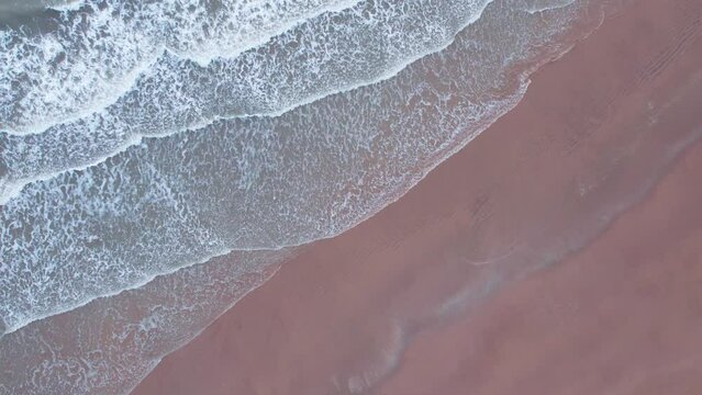 4K aerial view of calm ocean waves and sandy beach in Mandvi, Kutch, India. Top down view over ocean coast. Serene and Tranquil Landscape of beach.
