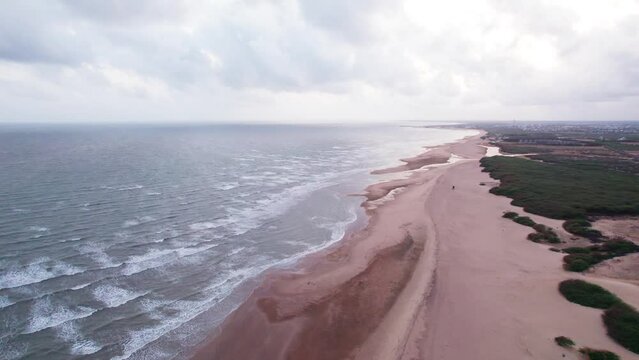 4K Aerial view of tropical sandy beach at Mandvi, Kutch, India. Beach waves and clouds in sky during monsoon season. Bird Eye View 4K Cinematic Drone Footage. Travel and holidays concept.