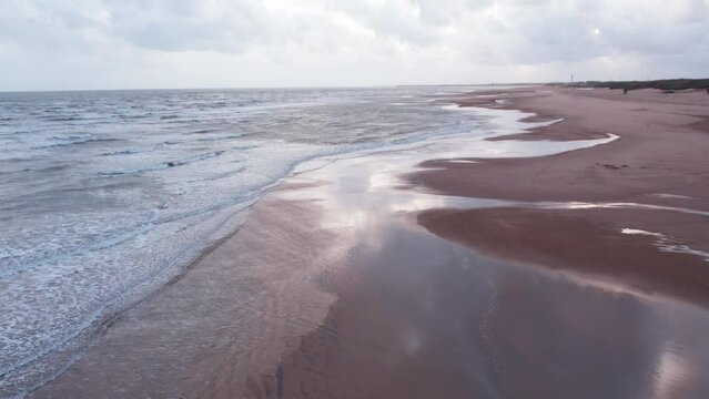 4K Aerial view of tropical sandy beach at Mandvi, Kutch, India. Beach waves and clouds in sky during monsoon season. Bird Eye View 4K Cinematic Drone Footage. Travel and holidays concept.