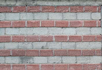 Pared con hileras de ladrillo rojo y gris.  