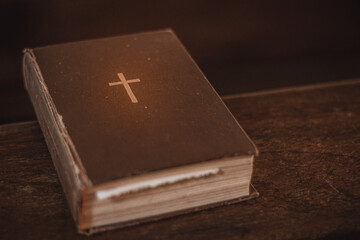 Bible on the church bench. God's word in one little book. Soft selective focus. Artificially...