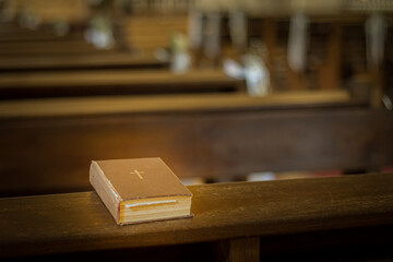 Bible on the church bench. God's word in one little book. Soft selective focus. Artificially...
