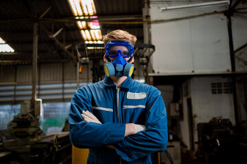 Professional male worker in protective suit and gas mask handling hazardous chemicals in a factory.