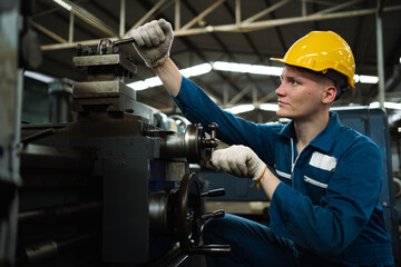 Male engineer in blue jumpsuit working in factory. Concept of working in a heavy metal factory