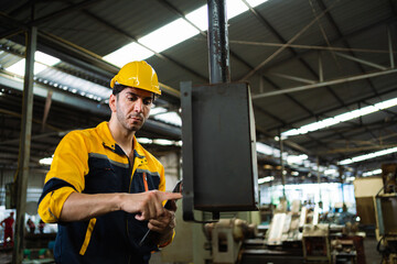 Factory engineers maintain industrial machinery. Metal manufacturing plants. At the metal factory, happy professional workers wear safety uniforms.