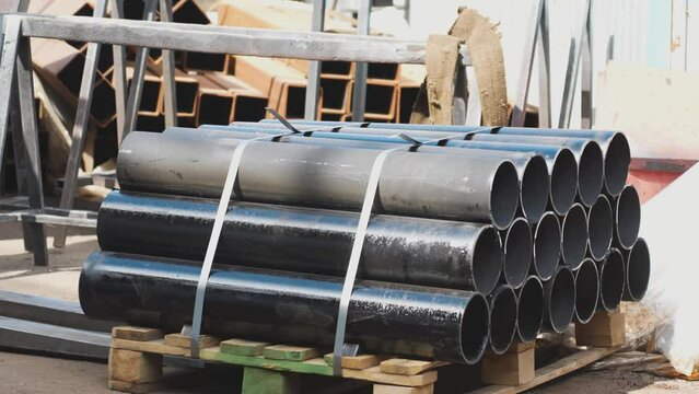 forklift puts a pallet of pipes