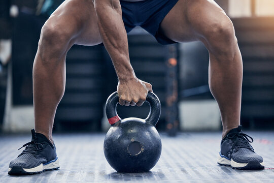 Fitness, floor and kettlebell with a bodybuilder man in the gym for a weightlifting workout routine. Exercise, hand and strong with a male athlete holding a weight in a sports club while training