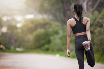 Nature, woman and warm up from back, workout motivation and fitness while stretching legs. Dedication, commitment and girl runner standing on road with leg stretch for outdoor run and exercise goals.