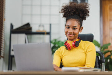 African American female college student studying online at home from computer and laptop.